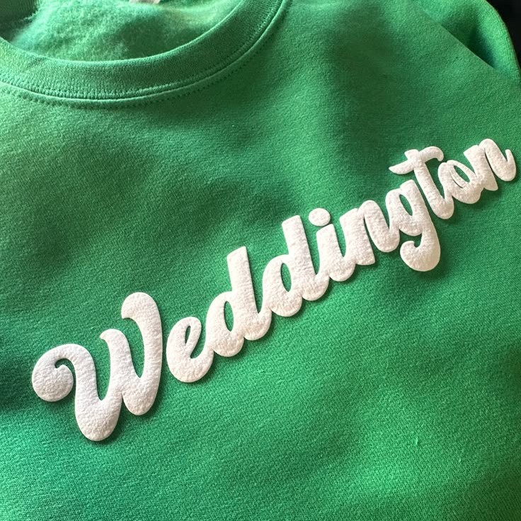 Raised white puff-print lettering on a green shirt